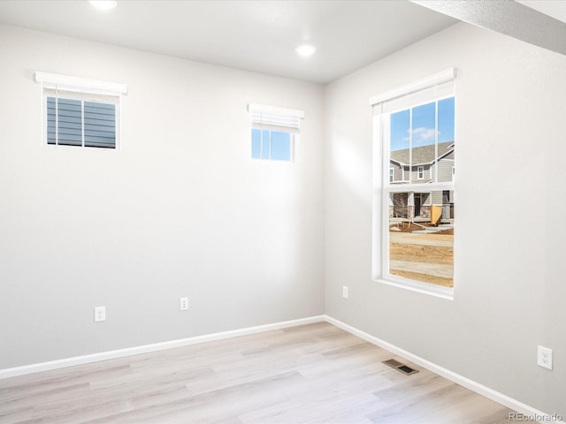 empty room with recessed lighting, wood finished floors, visible vents, and baseboards