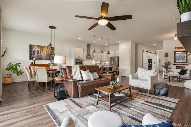 328 Simmental Loop, Castle Rock, CO 80104 - living area featuring a barn door, ceiling fan, light wood-style floors, baseboards, and recessed lighting