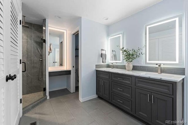 bathroom featuring tile patterned flooring, vanity, and a shower with shower door