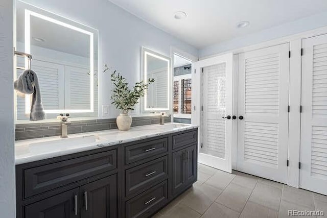 bathroom with vanity, tasteful backsplash, and tile patterned floors