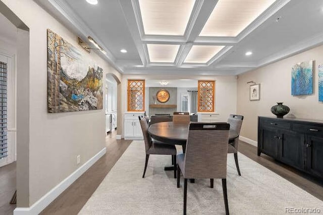 dining room featuring dark hardwood / wood-style floors, beam ceiling, crown molding, and coffered ceiling