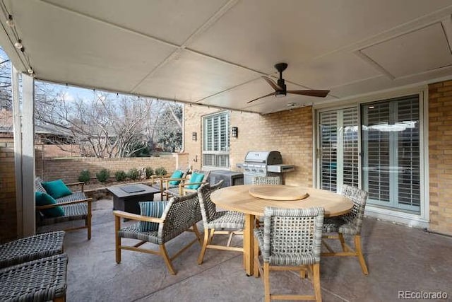 view of patio / terrace with a fire pit, ceiling fan, and area for grilling