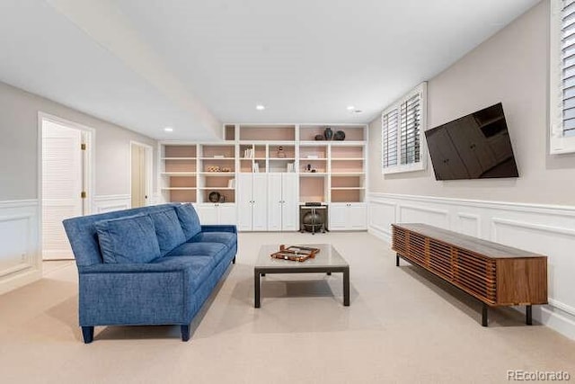 living room featuring built in shelves and light colored carpet