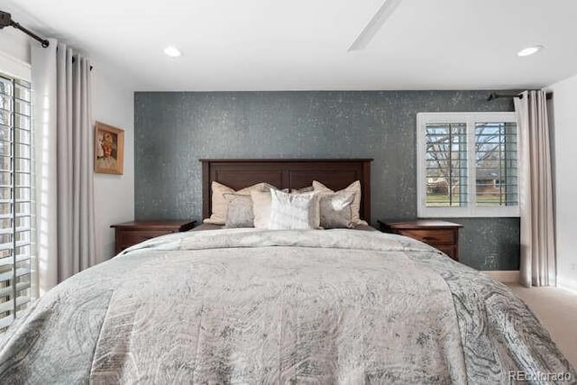 bedroom with ceiling fan and multiple windows