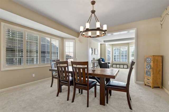 dining space featuring light colored carpet and a chandelier