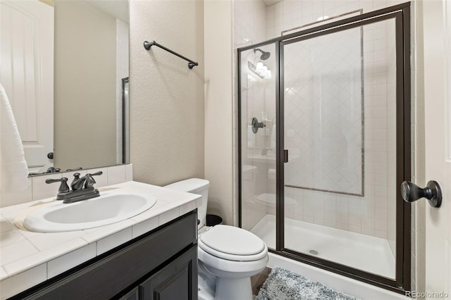 bathroom with walk in shower, vanity, and toilet