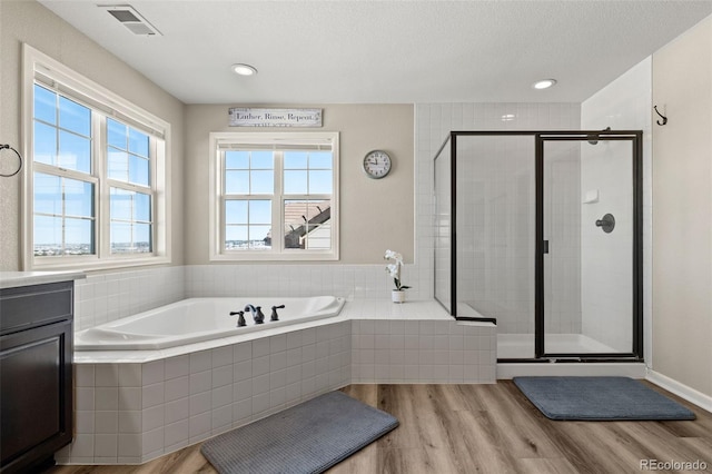 bathroom featuring vanity, shower with separate bathtub, hardwood / wood-style floors, and a textured ceiling