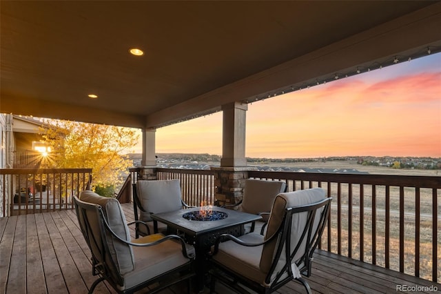 deck at dusk featuring a fire pit