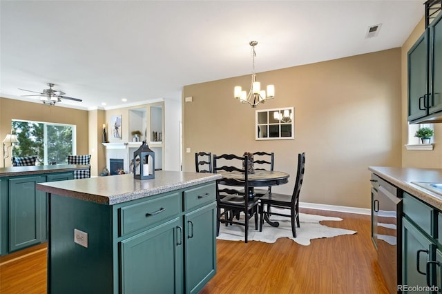 kitchen featuring stainless steel dishwasher, light hardwood / wood-style floors, decorative light fixtures, a kitchen island, and ceiling fan with notable chandelier