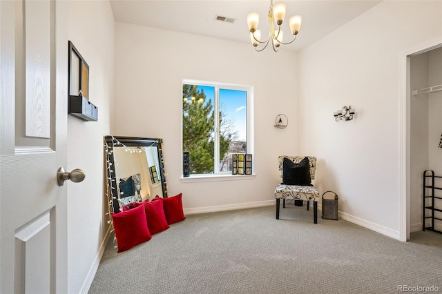 sitting room featuring a chandelier and carpet floors