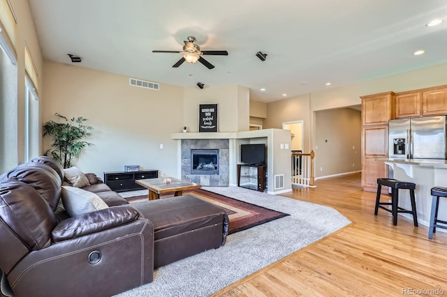 10117 Waco St, Commerce City, CO 80022 - living area with light wood-style flooring, ceiling fan, a tile fireplace, and recessed lighting