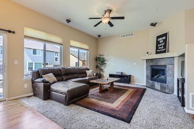 10117 Waco St, Commerce City, CO 80022 - living room featuring a ceiling fan, a tiled fireplace, and wood finished floors