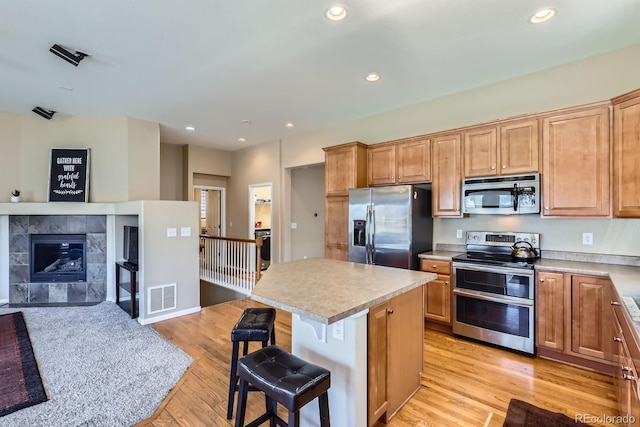 10117 Waco St, Commerce City, CO 80022 - kitchen featuring appliances with stainless steel finishes, a breakfast bar area, light wood-type flooring, a center island, and recessed lighting