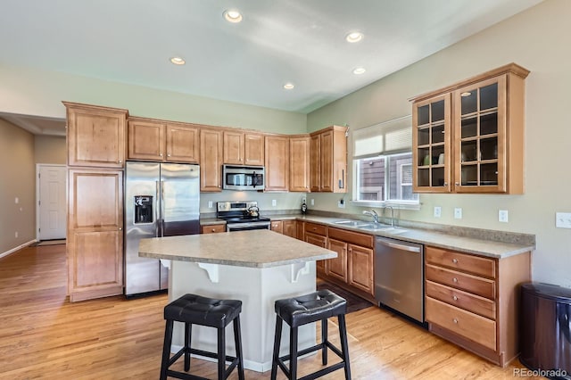 10117 Waco St, Commerce City, CO 80022 - kitchen with appliances with stainless steel finishes, a breakfast bar, light wood-type flooring, recessed lighting, and light countertops