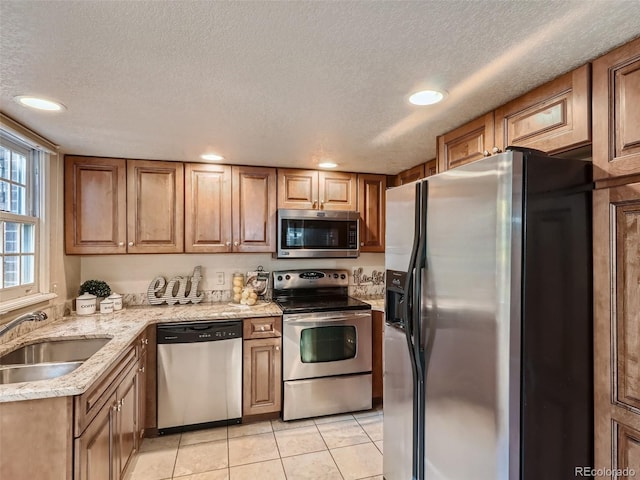 3540 E 5th Ave, Denver, CO 80206 - kitchen with appliances with stainless steel finishes, a sink, a textured ceiling, light tile patterned flooring, and light stone counters