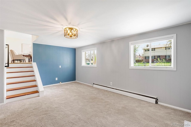 spare room featuring stairway, carpet floors, baseboards, and baseboard heating