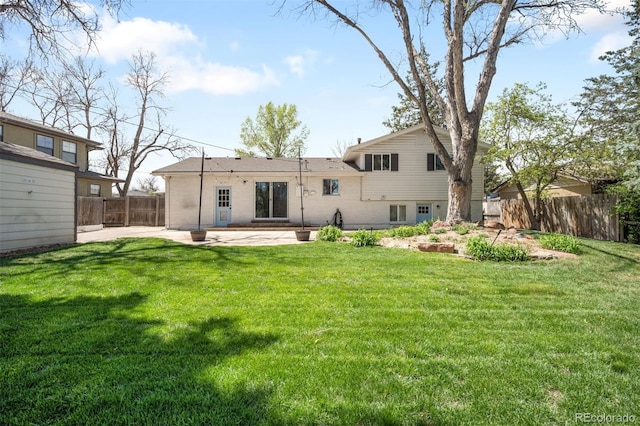 back of property featuring a lawn, a patio, and fence