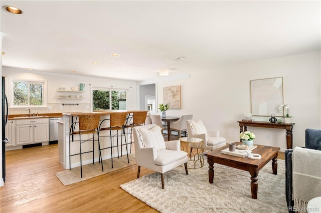sitting room with recessed lighting, light wood-style flooring, and crown molding