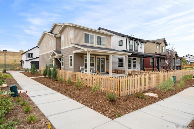 view of front of property featuring covered porch and a fenced front yard
