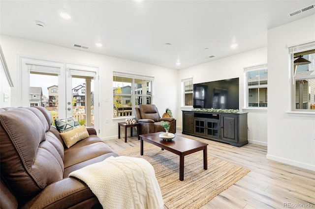 living area with visible vents, light wood finished floors, and a healthy amount of sunlight