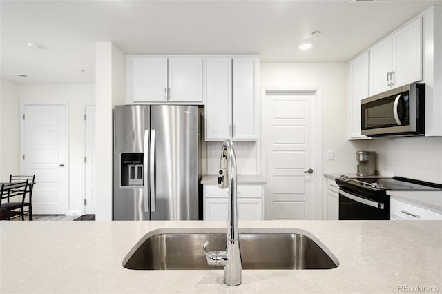 kitchen featuring a sink, light countertops, white cabinets, appliances with stainless steel finishes, and recessed lighting