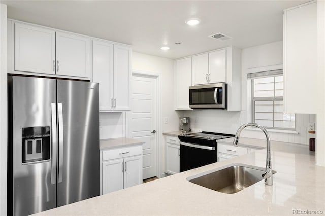 kitchen with stainless steel appliances, a sink, visible vents, recessed lighting, and white cabinetry