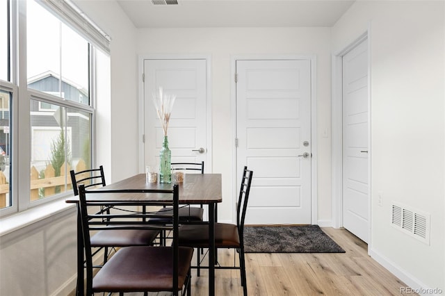 dining space with plenty of natural light, light wood-style flooring, visible vents, and baseboards