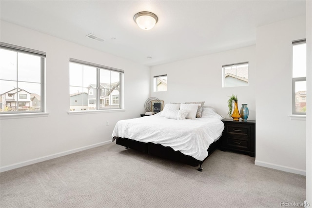 bedroom with baseboards, multiple windows, and visible vents