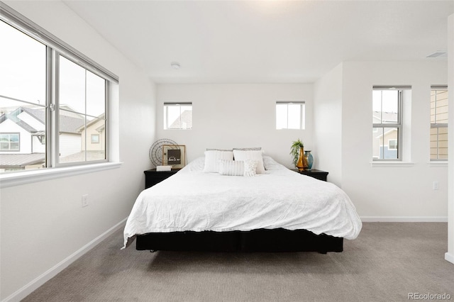carpeted bedroom with visible vents and baseboards
