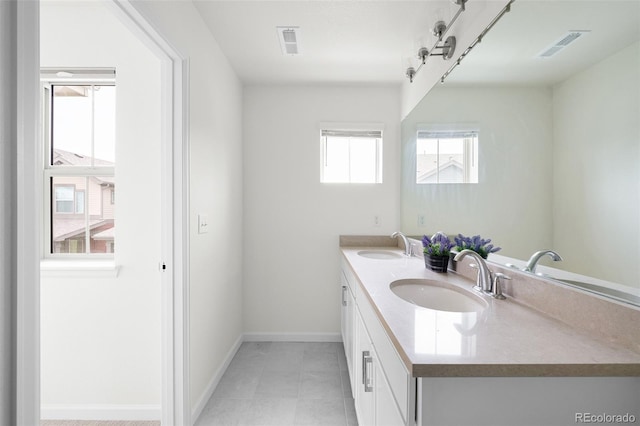 full bathroom featuring double vanity, visible vents, baseboards, and a sink