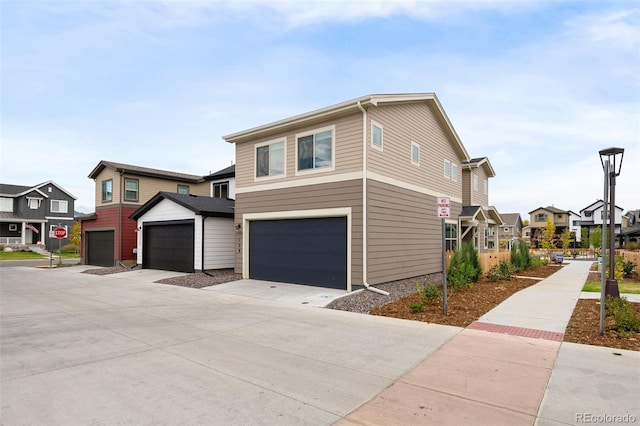 view of front facade with concrete driveway, an attached garage, and a residential view