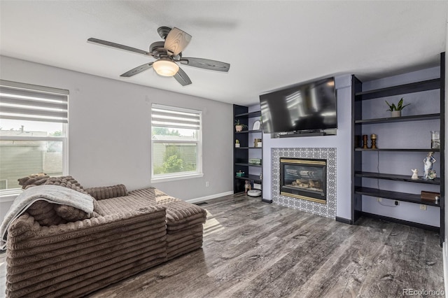 2634 E 132nd Ave, Thornton, CO 80241 - living room with a tiled fireplace, wood finished floors, a ceiling fan, and built in features