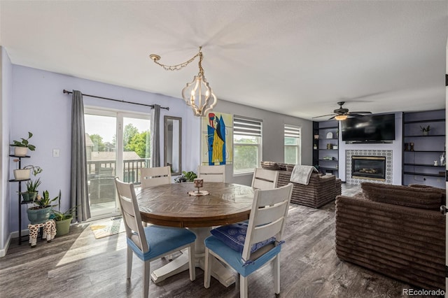 2634 E 132nd Ave, Thornton, CO 80241 - dining space featuring wood finished floors, a glass covered fireplace, a ceiling fan, and a chandelier
