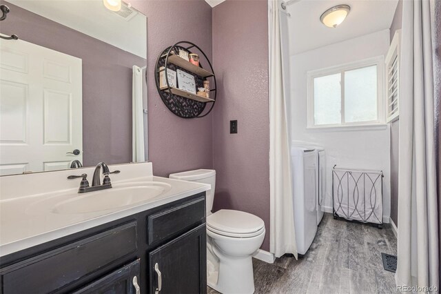 2634 E 132nd Ave, Thornton, CO 80241 - bathroom with washing machine and clothes dryer, wood finished floors, vanity, and a textured wall