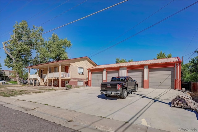 1291 W 3rd Ave, Broomfield, CO 80020 - view of front facade with a porch, metal roof, an outdoor structure, and a detached garage