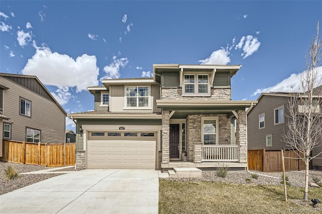 prairie-style home with stone siding, driveway, covered porch, and fence