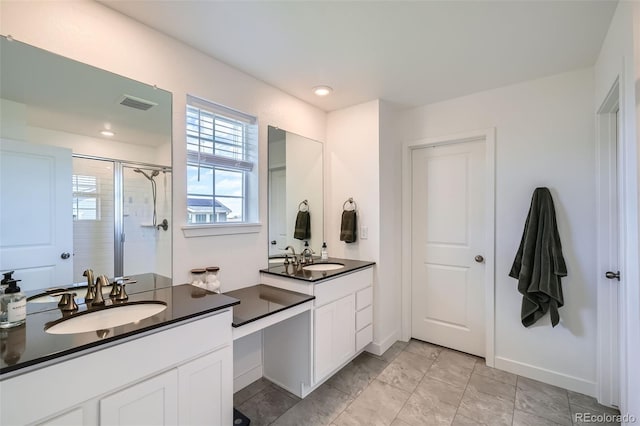 full bath featuring a sink, two vanities, a stall shower, and visible vents