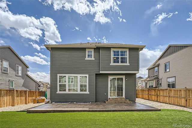back of property featuring a deck, a lawn, and a fenced backyard