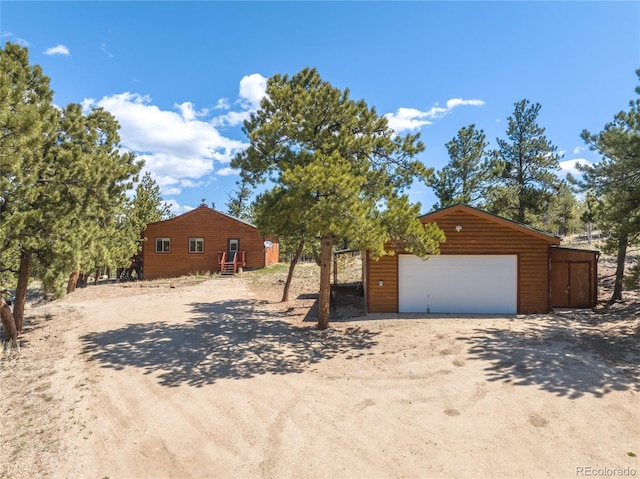 1948 Wagon Wheel Rd, Hartsel, CO 80449 - view of front of home with a garage, dirt driveway, and an outbuilding
