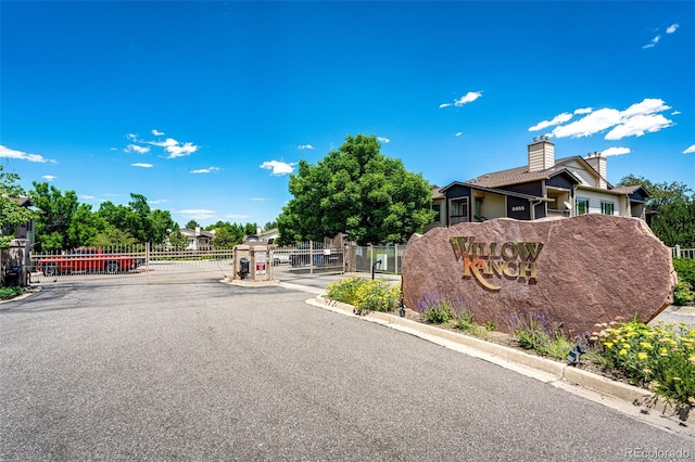 5439 S Dover St Unit 101, Littleton, CO 80123 - view of asphalt street with a gated entry, a gate, and curbs