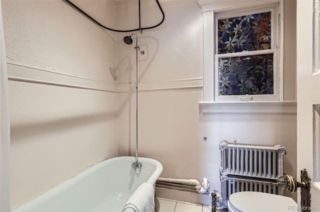 bathroom with a bathtub, radiator heating unit, tile patterned floors, and toilet