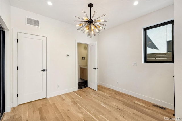 1735 Lowell Blvd, Denver, CO 80204 - unfurnished bedroom with baseboards, light wood finished floors, a chandelier, and visible vents