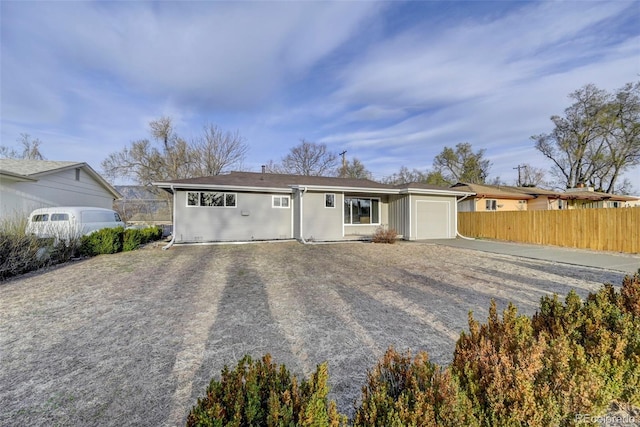view of front of property with a garage, driveway, and fence
