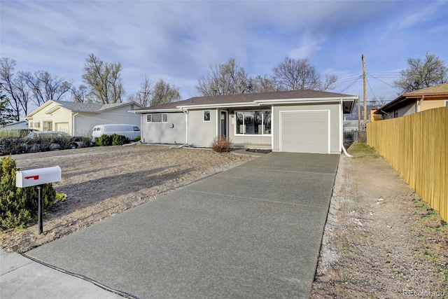 ranch-style home featuring concrete driveway, a garage, and fence