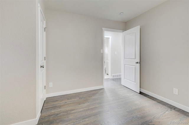 unfurnished room with visible vents, baseboards, and wood finished floors