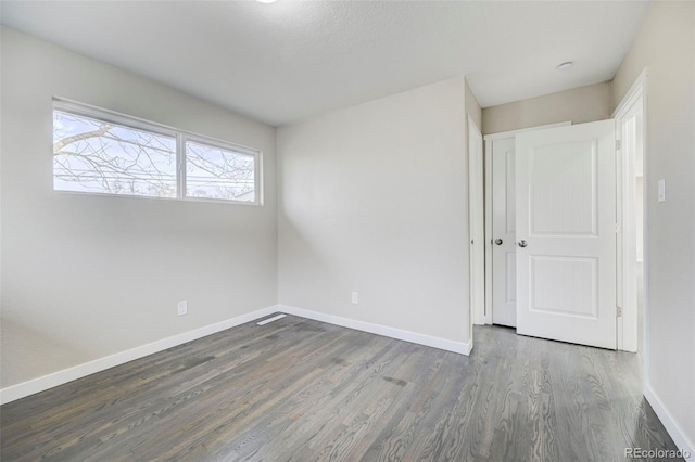 unfurnished room featuring baseboards and wood finished floors