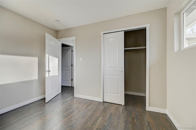 unfurnished bedroom featuring a closet, baseboards, and wood finished floors
