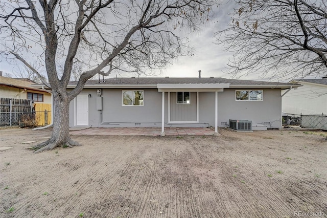 back of property featuring central AC unit, fence, crawl space, and stucco siding