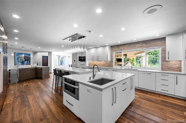 4766 S Fillmore Ct, Cherry Hills Village, CO 80113 - kitchen featuring a sink, a large island, recessed lighting, decorative backsplash, and white cabinets