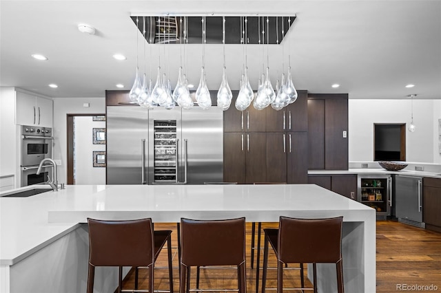 4766 S Fillmore Ct, Cherry Hills Village, CO 80113 - kitchen featuring wine cooler, a sink, stainless steel appliances, light countertops, and recessed lighting